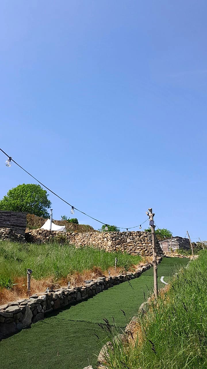 The lit grass path between stone walls at Fairy Hill