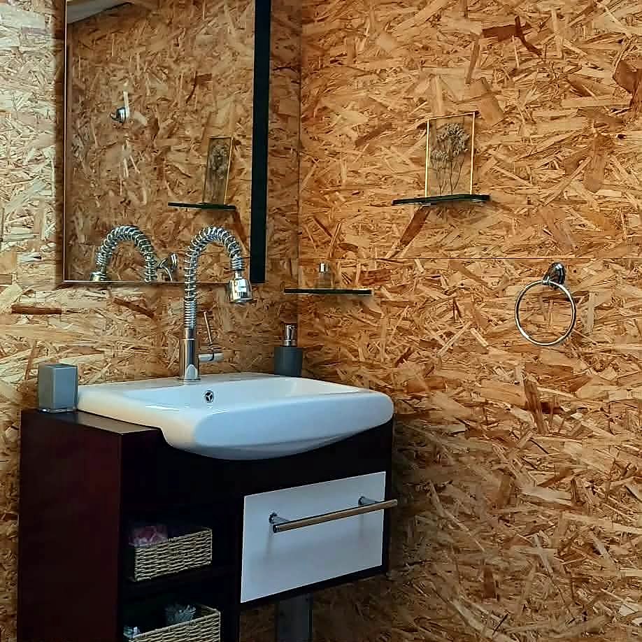 Wash area at Fairy Cove with a basin, mirror and dried flowers on timber walls