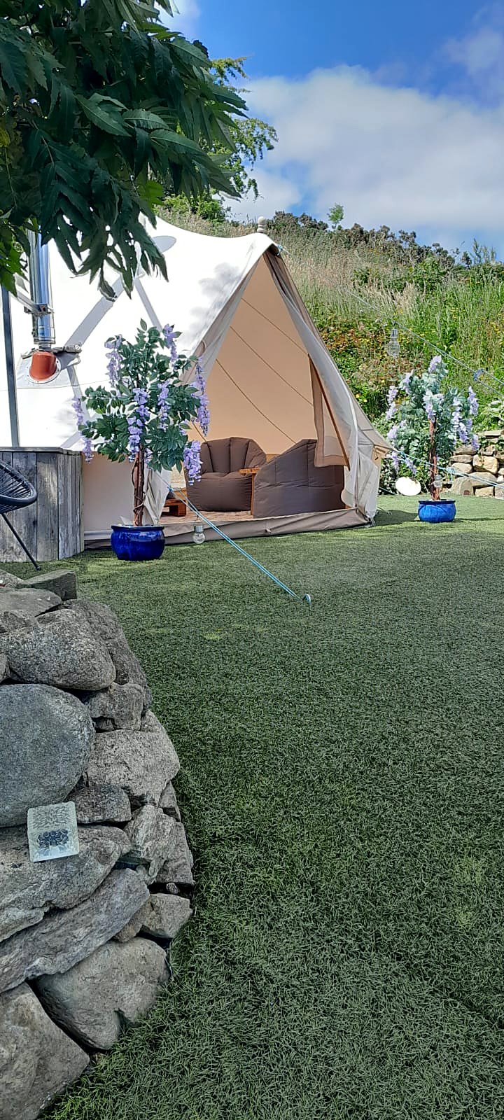 Fairy Fort bell tent open to the lawn under a clear blue sky at Rosemount Glamping, Carlingford
