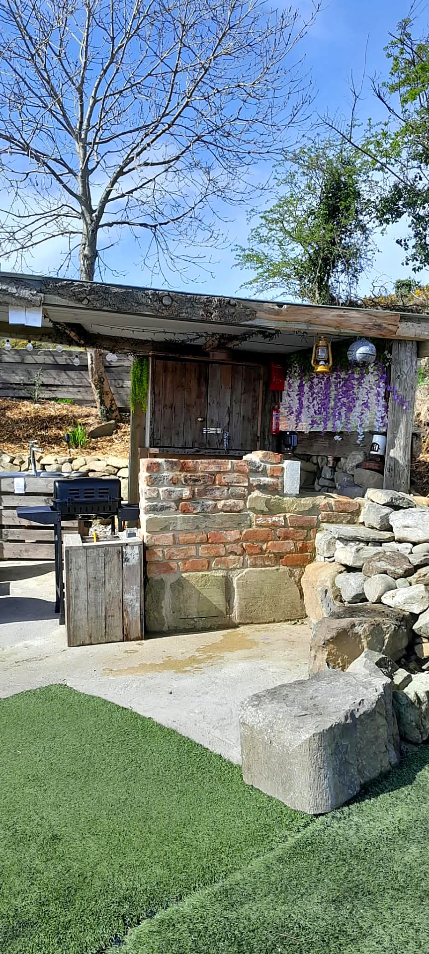 Timber-roofed cooking shelter at Fairy Cove with barbecue, brick counter and sink